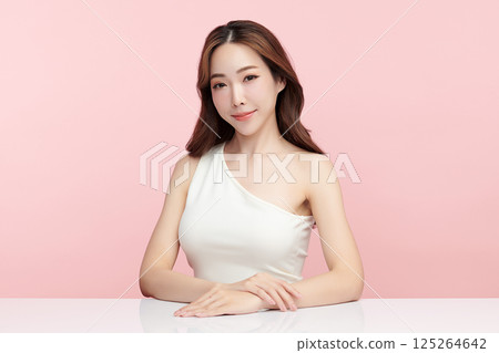 A beautiful young Asian woman with clean, fresh skin against a pink background. Skincare, facial treatment, cosmetology, beauty, and spa. An elegant portrait of an Asian woman. 125264642