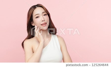 A beautiful young Asian woman with clean, fresh skin against a pink background. Skincare, facial treatment, cosmetology, beauty, and spa. An elegant portrait of an Asian woman. A beautiful young Asian woman with clean, fresh skin against a pink background. Skincare, facial treatment, cosmetology, beauty, and spa. An elegant portrait of an Asian woman. 125264644