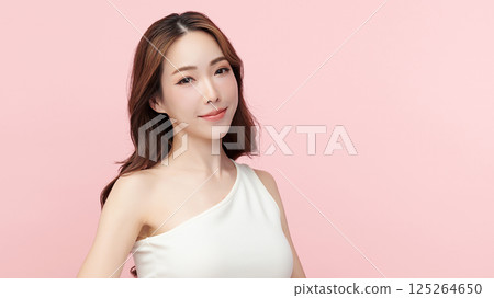 A beautiful young Asian woman with clean, fresh skin against a pink background. Skincare, facial treatment, cosmetology, beauty, and spa. An elegant portrait of an Asian woman. 125264650