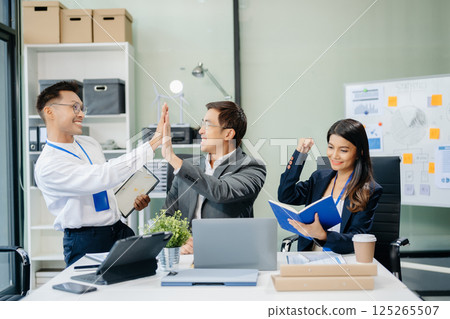 Happy Asian businesspeople while collaborating on a new project. using a laptop and tablet Happy Asian businesspeople while collaborating on a new project. using a laptop and tablet 125265507