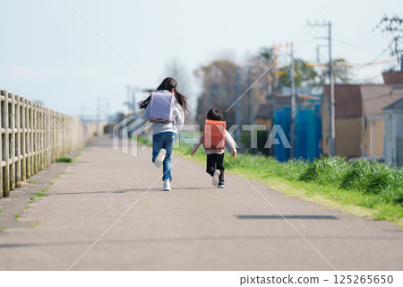 Siblings running with backpacks 125265650
