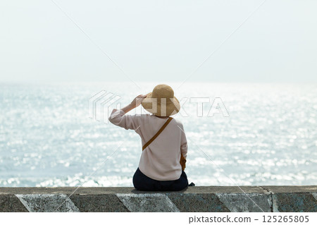 A middle-aged woman strolling along the seaside in spring 125265805