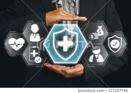 Conceptual image of health insurance with hands shielding medical and financial icons, symbolizing protection and security. 125267546