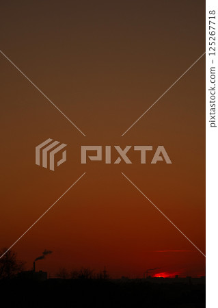 Dark orange skyline with factory smoke twilight hour 125267718