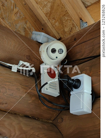 security equipment mounted under roof wooden house during daylight hours. security equipment mounted under roof wooden house during daylight hours. 125268626