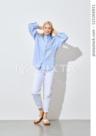 Blonde woman in jeans and button down shirt Blonde woman in jeans and button down shirt 125268931