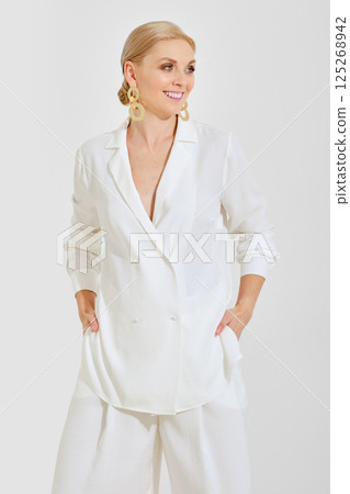 Elegant woman in white attire showcasing stylish fashion trends indoors 125268942