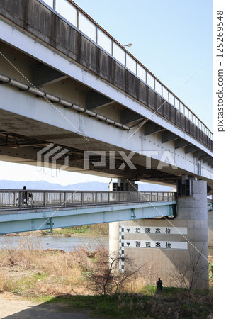 A large bridge over the Katsura River and people A large bridge over the Katsura River and people 125269548