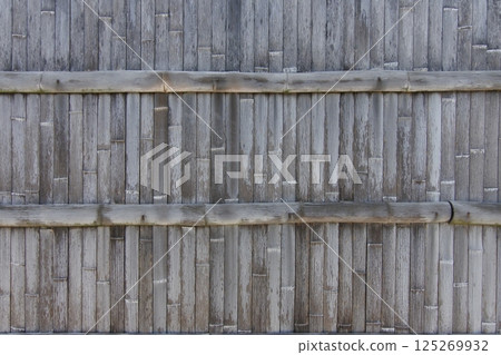 An old, blackened bamboo fence 125269932