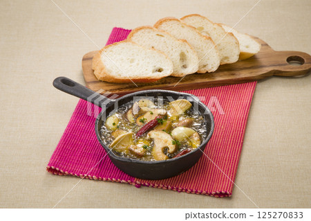 Hot mushroom ajillo and baguette 125270833