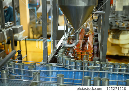 Automated factory line filling metal cans with food product in an industrial processing plant Automated factory line filling metal cans with food product in an industrial processing plant 125271228