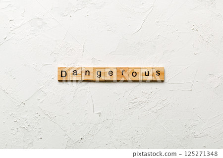 dangerous word written on wood block. dangerous text on cement table for your desing, concept 125271348
