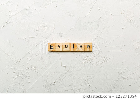 EVOLVE word written on wood block. EVOLVE text on cement table for your desing, concept EVOLVE word written on wood block. EVOLVE text on cement table for your desing, concept 125271354
