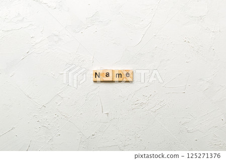 NAME word written on wood block. NAME text on cement table for your desing, concept NAME word written on wood block. NAME text on cement table for your desing, concept 125271376