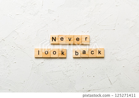 never look back word written on wood block. never look back text on cement table for your desing, concept 125271411
