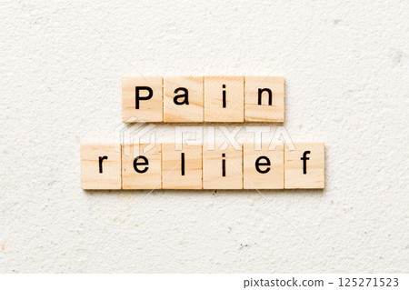 pain relief word written on wood block. pain relief text on table, concept 125271523