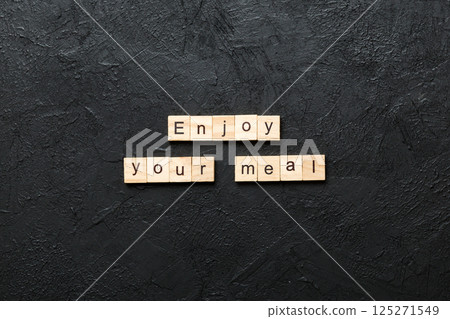 Enjoy your meal word written on wood block. Enjoy your meal text on cement table for your desing, concept 125271549