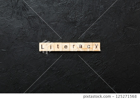LITERACY word written on wood block. LITERACY text on cement table for your desing, concept LITERACY word written on wood block. LITERACY text on cement table for your desing, concept 125271568