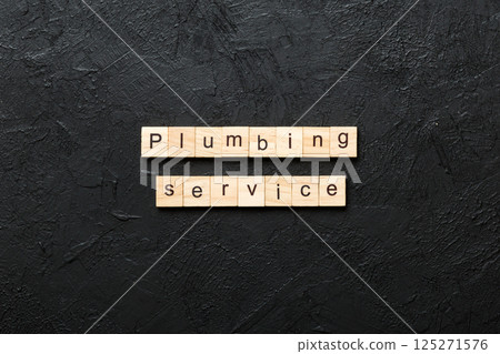 Plumbing service word written on wood block. Plumbing service text on cement table for your desing, concept Plumbing service word written on wood block. Plumbing service text on cement table for your desing, concept 125271576