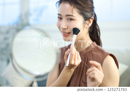 一位年輕的女士化妝 一位年輕的女士化妝 125271783