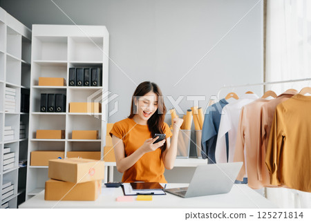 Asian lady blogger showing clothes in front of the camera to recording vlog video live streaming at her shop. Online Shopping Asian lady blogger showing clothes in front of the camera to recording vlog video live streaming at her shop. Online Shopping 125271814