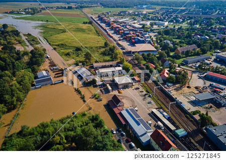 Aerial view of flooded streets, railway tracks and buildings in a suburban area. Industrial zone with floodwater after heavy rain. Concept of natural disaster, climate impact and emergency 125271845