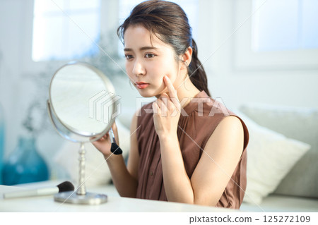 一位正在接受皮膚護理的年輕女性擔心皮膚粗糙 一位正在接受皮膚護理的年輕女性擔心皮膚粗糙 125272109
