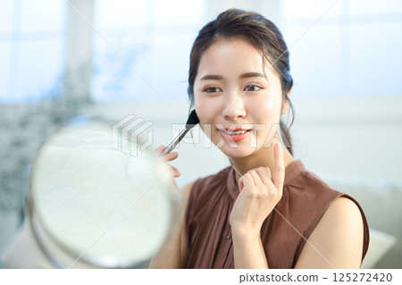 一位年輕的女士化妝 一位年輕的女士化妝 125272420