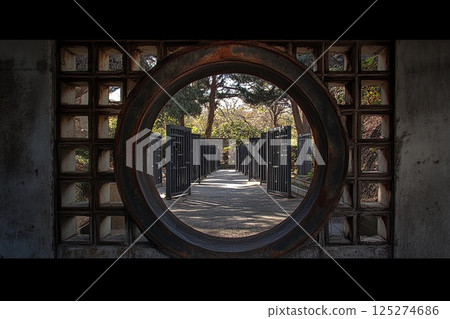 Round gate leading to a series of similar gates in a serene outdoor environment 125274686