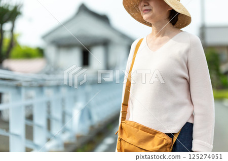 一位中年女性在復古的街道上觀光 一位中年女性在復古的街道上觀光 125274951