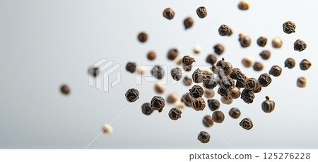 Black peppercorns floating in air, copy space, macro shot 125276228