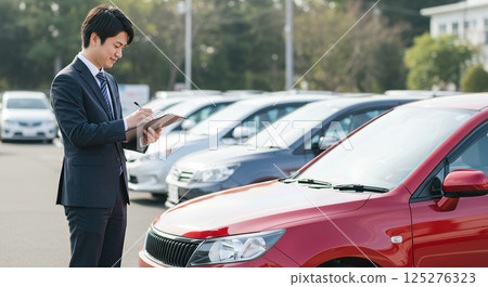 Asian businessman doing car appraisal Asian businessman doing car appraisal 125276323
