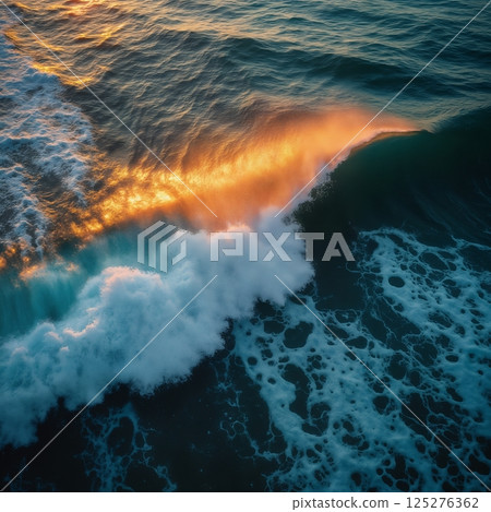 an impressive seascape view from above, a large and beautiful ocean wave on the beach, at sunset, sunlight and wind breaking through the crest of the wave, beautiful nature as a background 125276362
