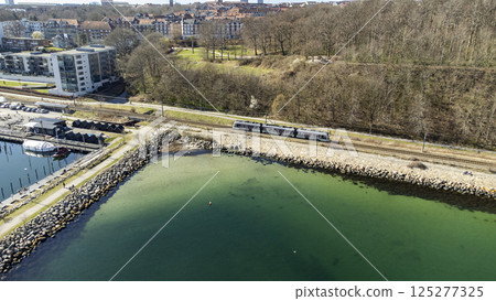 Tram-train driving along the coast, close to the Troejborg area in Aarhus Tram-train driving along the coast, close to the Troejborg area in Aarhus 125277325