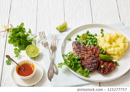grilled beef cutlets with potato mash, green peas grilled beef cutlets with potato mash, green peas 125277757