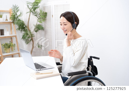 Woman in wheelchair online headset Woman in wheelchair online headset 125277925