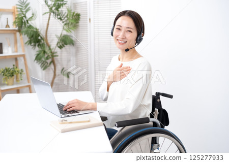 Woman in wheelchair online headset 125277933