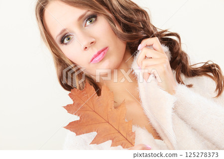 Pretty autumnal girl with oak leaf in hand 125278373