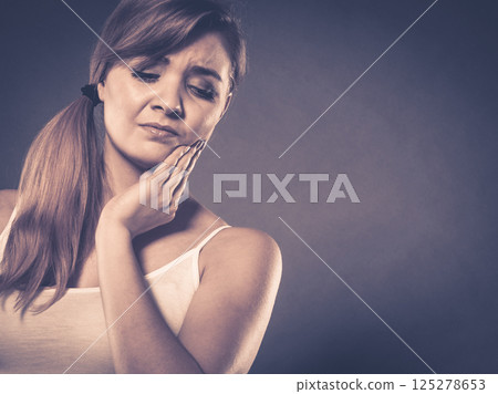 Woman suffering from tooth pain 125278653
