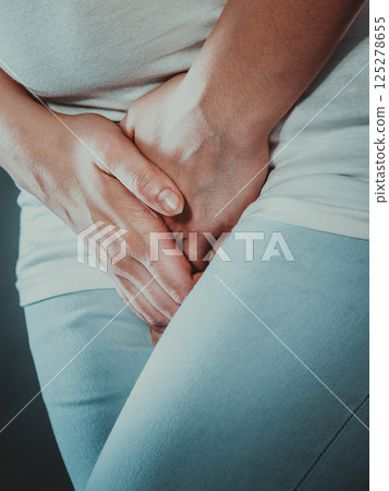 woman with hands holding her crotch 125278655