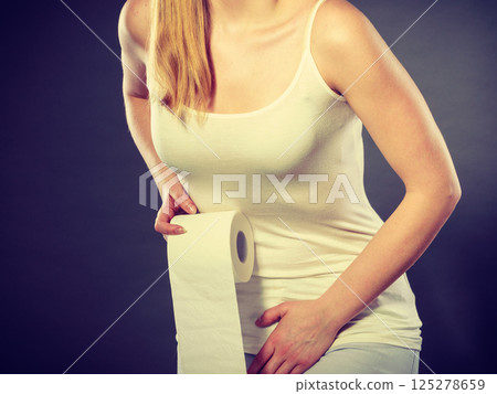 woman with hands holding her crotch in toilet 125278659
