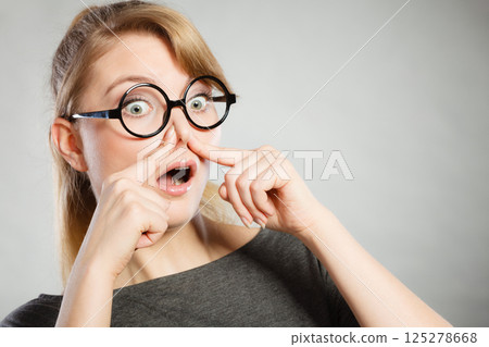 Girl pinches her nose because of stench stink. Girl pinches her nose because of stench stink. 125278668