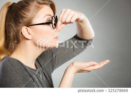 Girl pinches her nose because of stench stink. Girl pinches her nose because of stench stink. 125278669