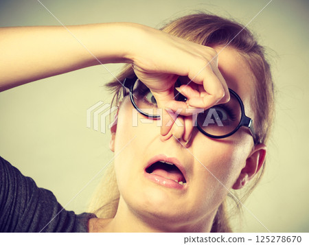 Girl pinches her nose because of stench stink. 125278670