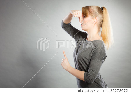 Blonde girl holding nose. Blonde girl holding nose. 125278672