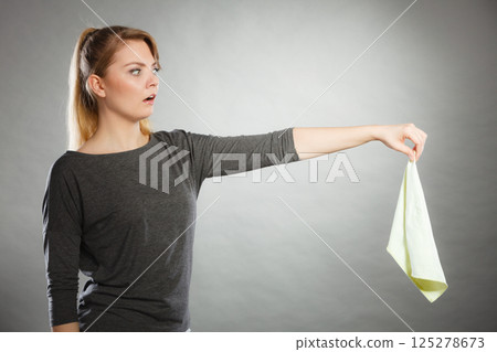 Disgusted woman holds dirty rag. 125278673