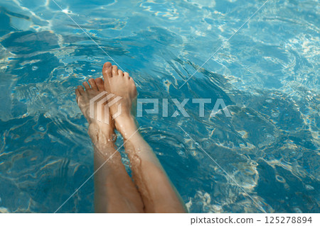 A girl's feet in a blue pool. Epilation of legs, varicose veins. Rest, relaxation on the beach, at the hotel. A woman in freedom. Vacation. High quality photo 125278894