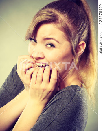 Nervous girl biting nails. 125278999