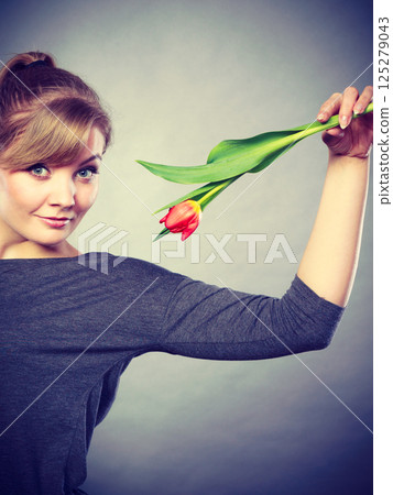 Playful girl having fun with flower tulip. 125279043