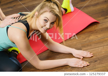 Woman in sportswear doing workout with trainer 125279337